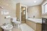 Full bath featuring tile walls, a bath, light tile patterned floors, a stall shower, and vanity