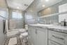 Bathroom with shower / bath combination with glass door, vanity, tile walls, and recessed lighting