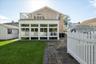 Back of property featuring brick siding, a yard, a balcony, and a patio