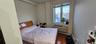 Bedroom featuring dark wood-style flooring, an AC wall unit, and a baseboard radiator