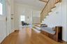 Entrance foyer white oak flooring, stairs to second floor, and entry to living room