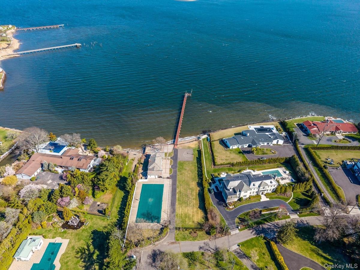 Aerial view of property and surrounding area featuring a pool area and nearby suburban area