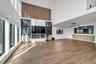 Unfurnished living room with a towering ceiling and light wood-type flooring