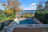 View of swimming pool with a water view, a fenced backyard, and a patio
