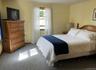 Bedroom featuring light carpet and baseboards