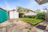 Fenced backyard with an outdoor structure and a patio