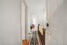 Hallway featuring dark wood-style floors, a textured ceiling, an upstairs landing, and a textured wall