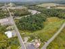 Aerial view of property and surrounding area with a heavily wooded area
