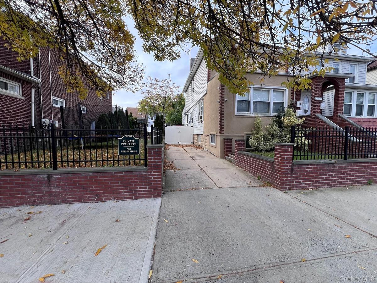 View of side of property featuring a fenced front yard and concrete driveway