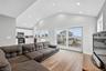 Living room with high vaulted ceiling, and water view
