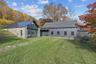 Back of house featuring a lawn, a standing seam roof, and a shingled roof