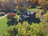 Aerial view of property and surrounding area with a forest