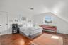 Bedroom with hardwood / wood-style floors and lofted ceiling