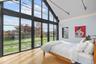 Bedroom with wood finished floors, high vaulted ceiling, and rail lighting