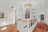 Hall featuring an upstairs landing, hardwood / wood-style floors, and lofted ceiling
