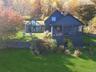 Back of property with a sunroom, a yard, and a chimney
