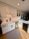 Kitchen with sink, wine cooler, light hardwood / wood-style floors, white cabinetry, and stainless steel appliances