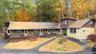 Rustic home with a porch, roof with shingles, and view of scattered trees