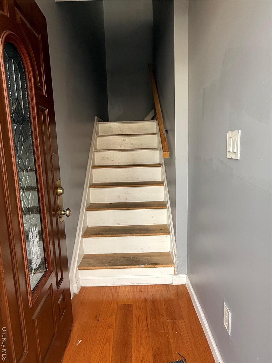 Stairs featuring wood finished floors and baseboards