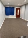 Foyer with dark colored carpet and recessed lighting