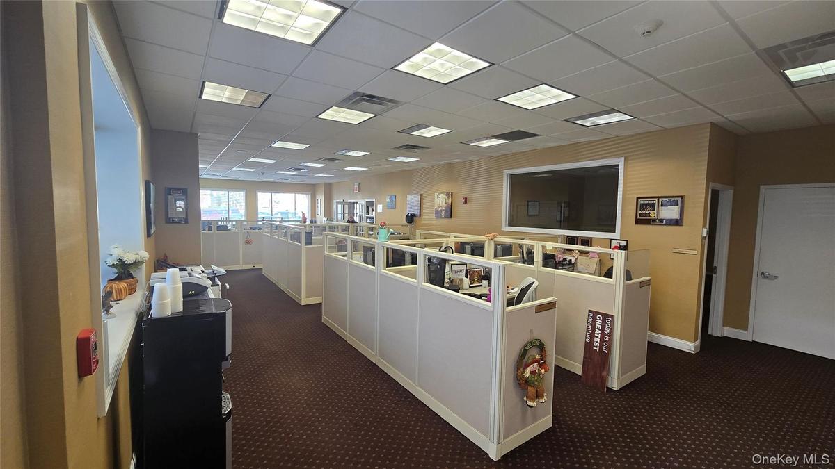 Living area with a drop ceiling and dark carpet