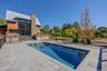 Outdoor pool featuring a patio and view of scattered trees