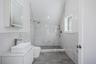 Bathroom featuring toilet, walk in shower, tile walls, and vanity