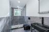 Full bath with tile walls, a shower stall, toilet, and vanity