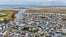 Aerial overview of property's location with nearby suburban area and a nearby body of water