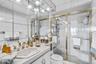 Full bathroom with tile walls, vanity, and a stall shower