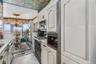 Kitchen featuring decorative light fixtures, light tile patterned flooring, gas stove, a chandelier, and light countertops