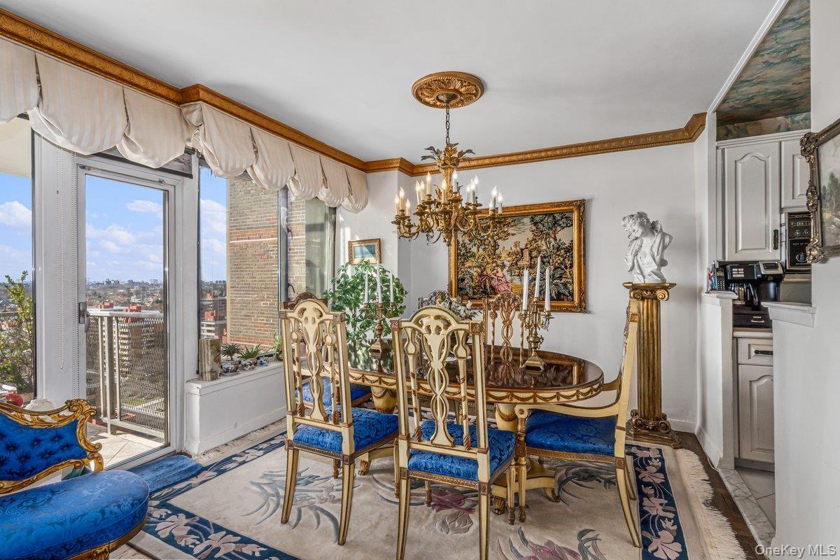 Dining space with ornamental molding and a chandelier