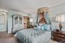 Bedroom featuring carpet, connected bathroom, and a chandelier