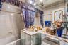 Full bathroom with a bathtub, vanity, and tile walls