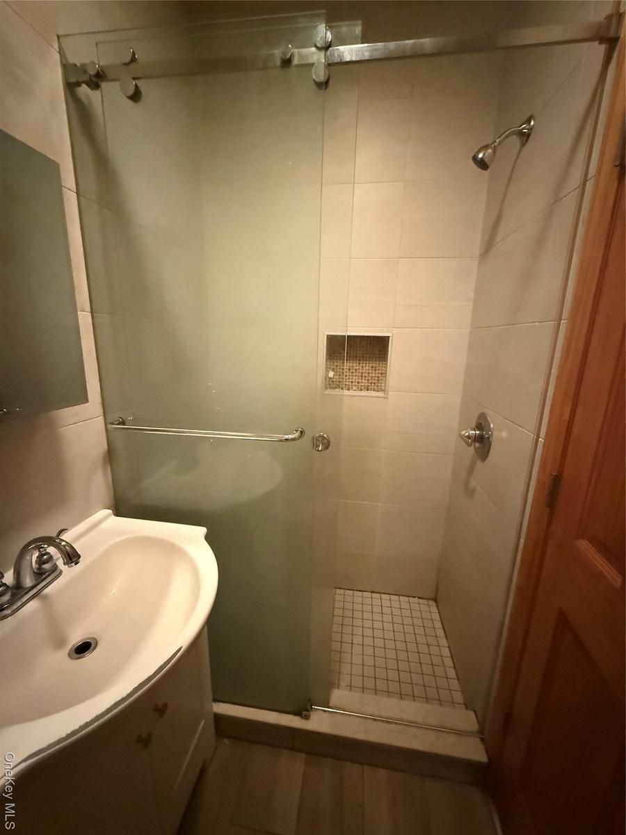Bathroom featuring vanity, a shower stall, and wood finished floors