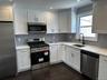 Kitchen with stainless steel appliances, dark wood-style flooring, recessed lighting, tasteful backsplash, and light stone countertops