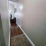 Hall with dark wood-style floors and baseboards