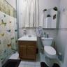 Bathroom featuring tile walls, vanity, curtained shower, and light tile patterned floors