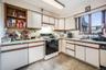 Kitchen with white cabinetry, sink, and white appliances