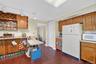 Kitchen with white appliances, brown cabinets, light countertops, and dark wood finished floors