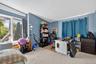 Carpeted bedroom with an AC wall unit