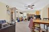 Living room featuring a fireplace, carpet floors, french doors, and a ceiling fan