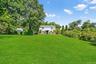 View of grassy yard featuring view of scattered trees