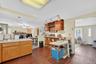 Kitchen featuring a stone fireplace, a peninsula, light countertops, and open floor plan