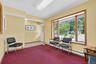 Sitting room with a baseboard heating unit and light colored carpet