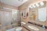 Bathroom featuring wallpapered walls, vanity, and combined bath / shower with glass door