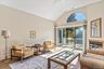 Carpeted living area featuring high vaulted ceiling and ceiling fan