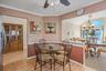 Dining area featuring crown molding, a chandelier, light wood-type flooring, and a ceiling fan