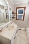 Bathroom with shower / bath combination with glass door, vanity, crown molding, baseboard heating, and light tile patterned floors