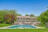 Rear view of house with stairs, a wooden deck, and an outdoor pool